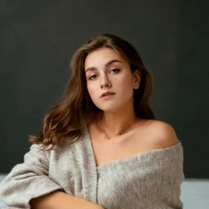 a woman sitting on a bed with her arms crossed