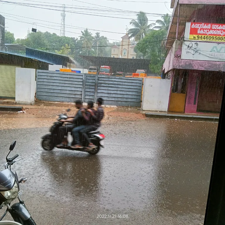 a group of people riding on the back of a motorcycle. wheel, tire, vehicle, automotive tire, water, motor vehicle, mode of transport, asphalt, sky, road surface