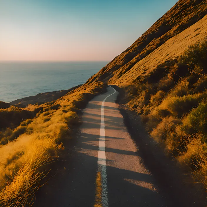 a road going up the side of a hill near the ocean