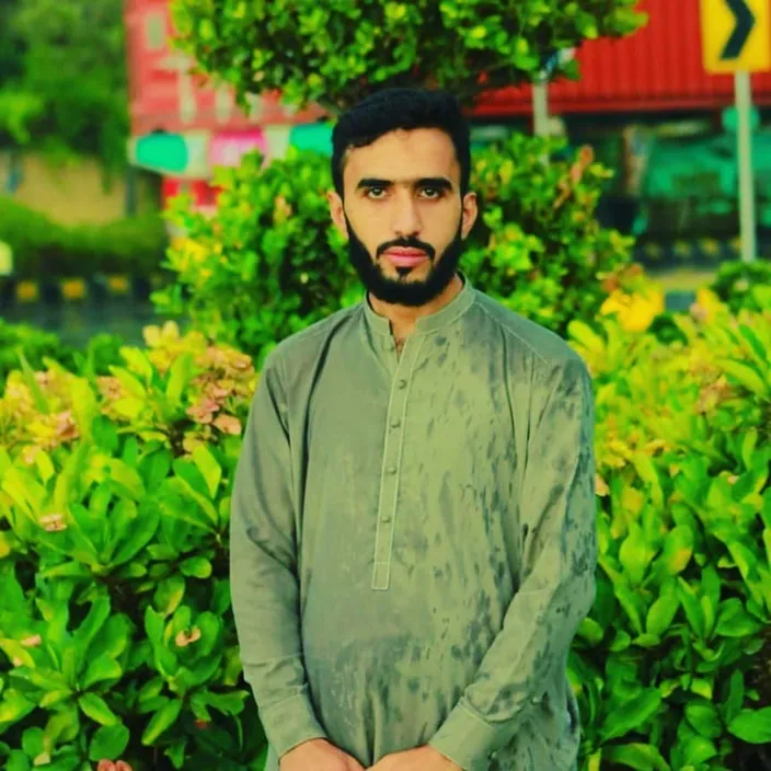 a man standing in front of some bushes