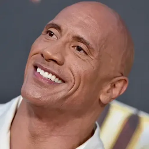 a bald man smiling and wearing a white shirt