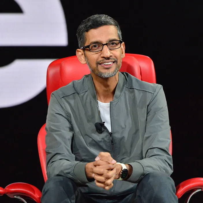 a man in glasses sitting in a red chair