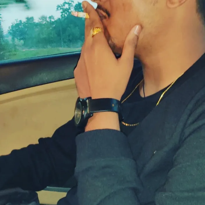 a man sitting in a car smoking a cigarette