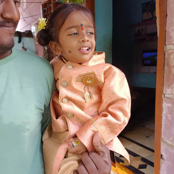 a man holding a little girl with a smile on her face