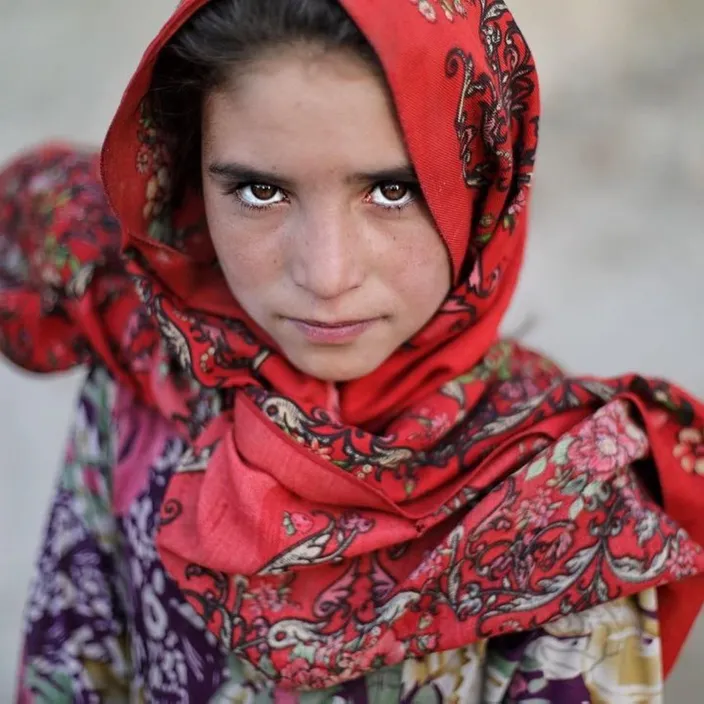 a young girl wearing a red head scarf