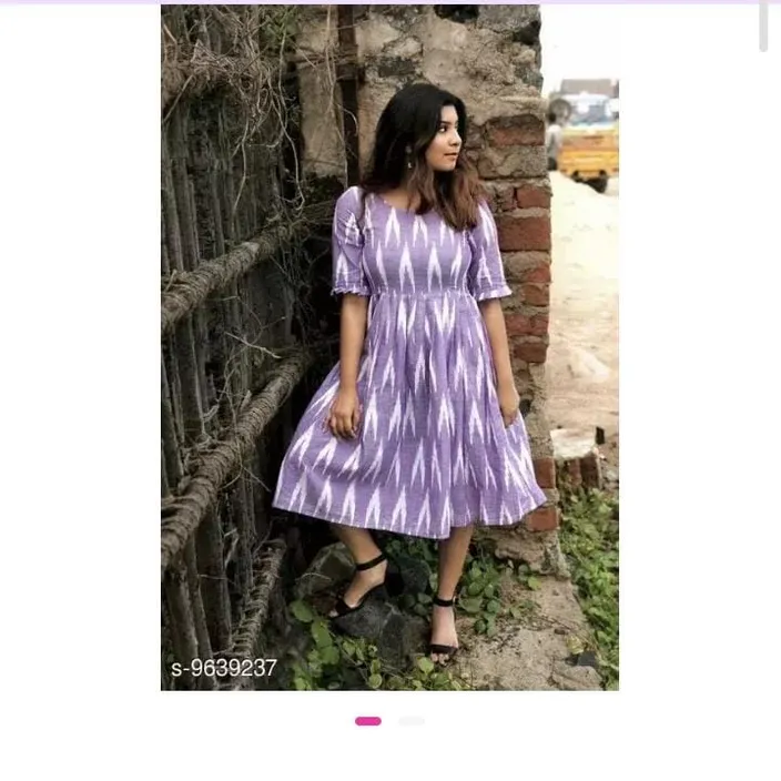 a woman standing next to a brick wall