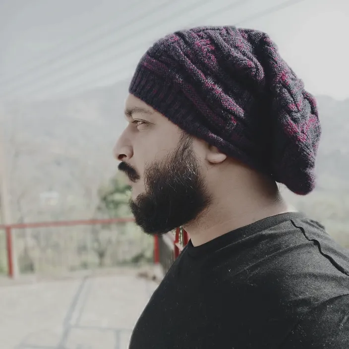 a man with a beard wearing a knitted hat