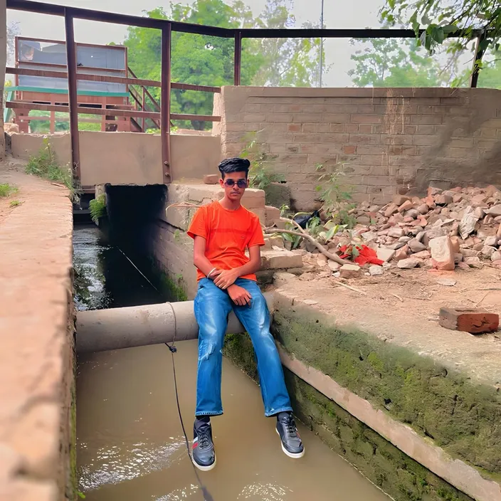 a man in an orange shirt is sitting on a ledge