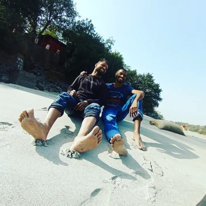 a couple of people sitting on top of a sandy beach