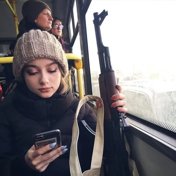 a woman on a bus looking at her cell phone