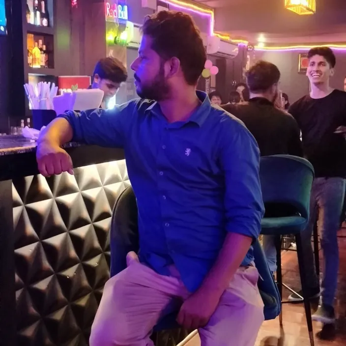 a man sitting at a bar in front of a tv