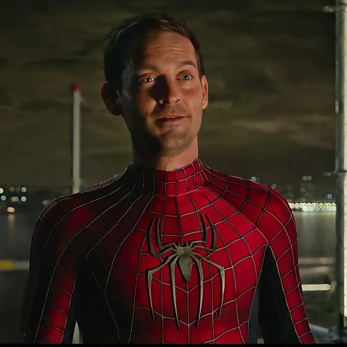a man in a spider - man suit looks into the camera