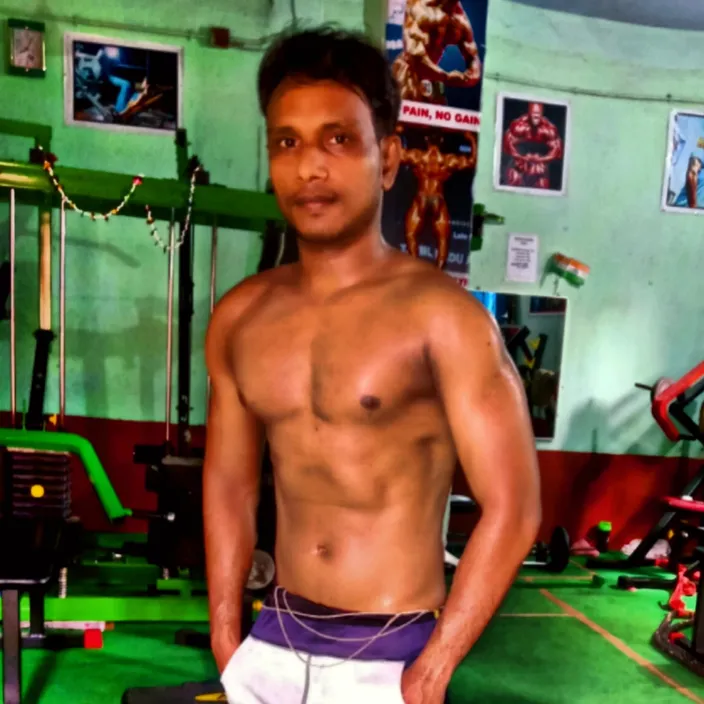 a man standing in a gym with no shirt on