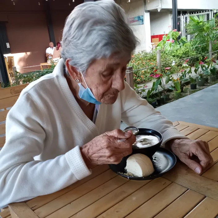 a woman sitting at a table eating food