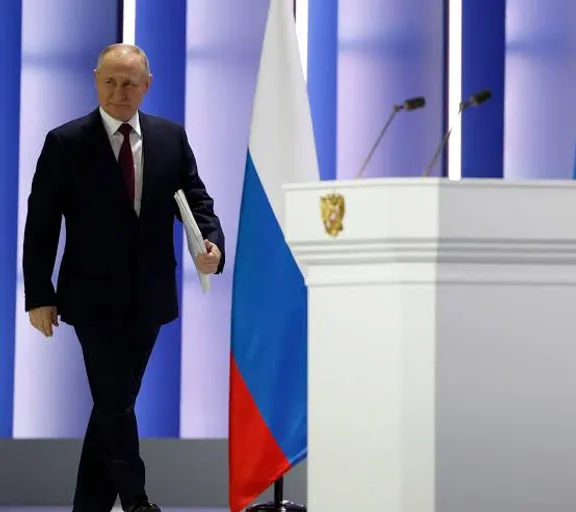 a man in a suit and tie walking past a podium