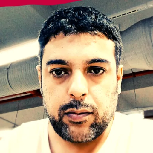 a man in a white shirt is looking at the camera