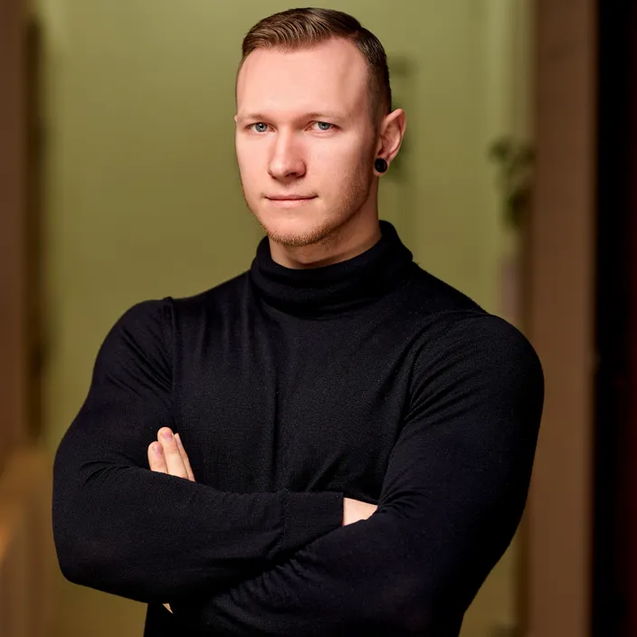 a man in a black turtle neck shirt with his arms crossed