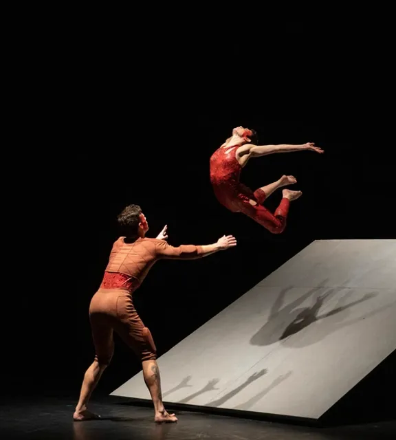 two dancers in the air on a stage