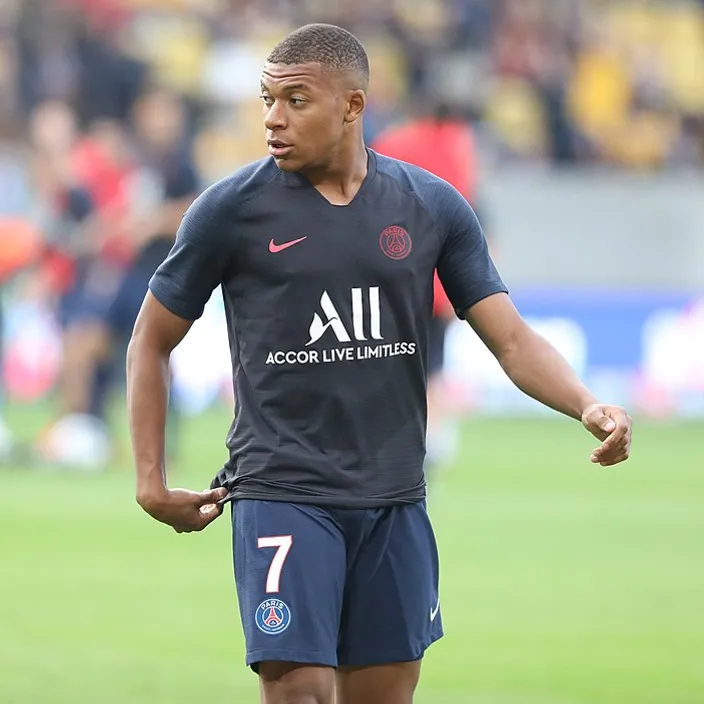 Mbappe standing on top of a soccer field make him look like a real kylian mbappe