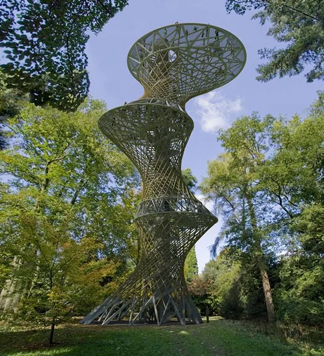 a tall metal sculpture in the middle of a park