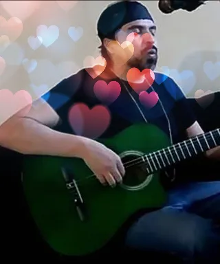 a man sitting on a couch playing a guitar