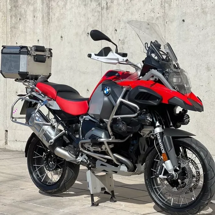 a red and black motorcycle parked next to a wall