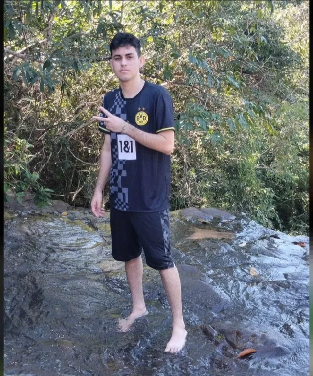 a man standing on top of a rock next to a river