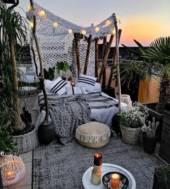 a bed sitting on top of a wooden floor next to potted plants