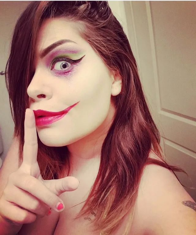 a woman with makeup on her face posing for a picture