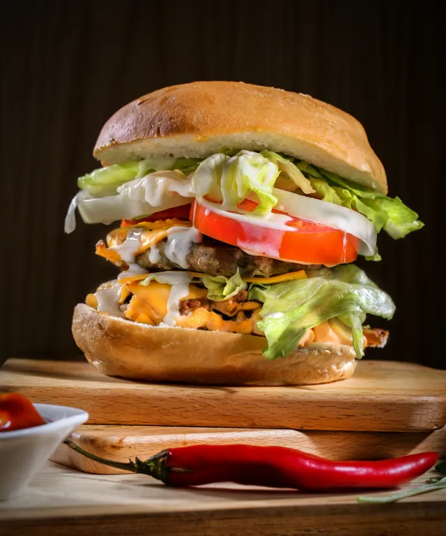 a large sandwich sitting on top of a wooden cutting board