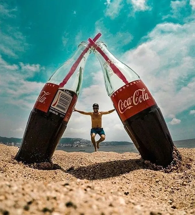 a man is jumping out of two coca cola bottles