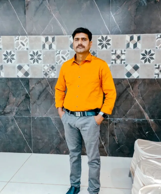 a man standing in front of a marble wall