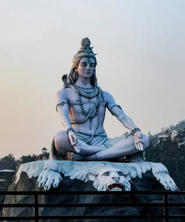 a statue of a man sitting on top of a white dog