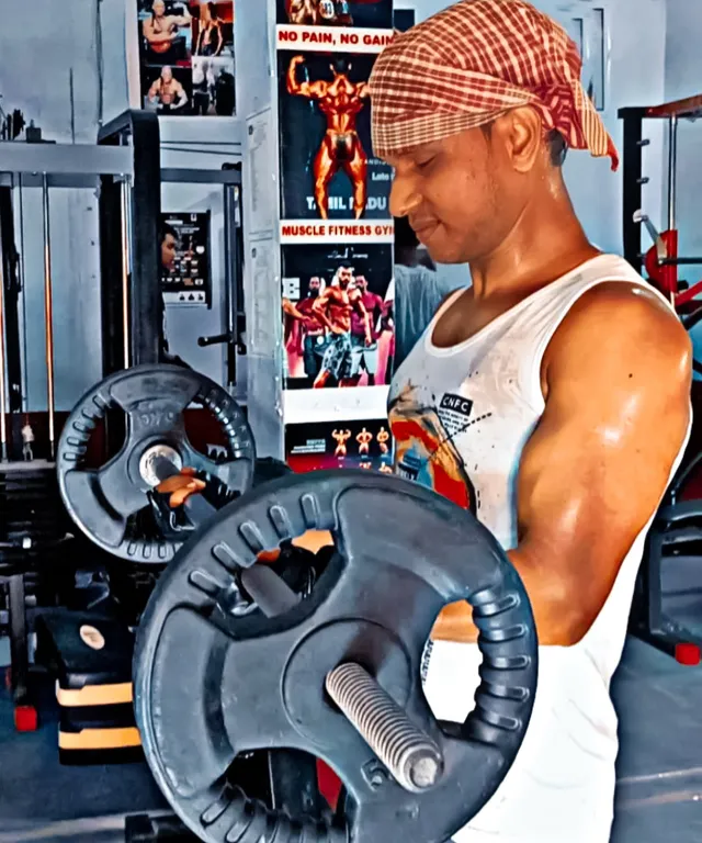 a man in a white tank top is holding a dumbbell