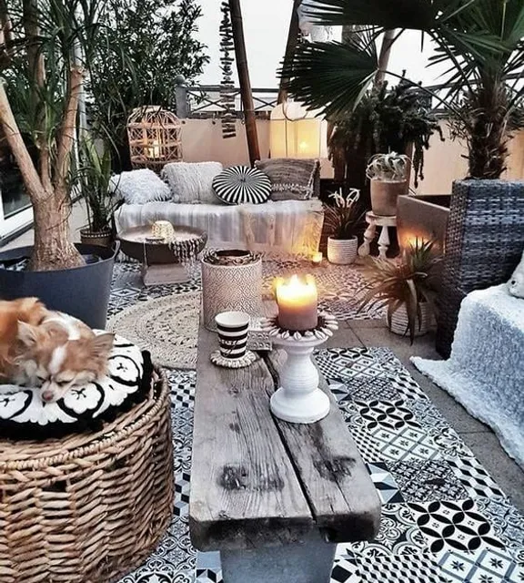 a cat sleeping on a wicker basket on a patio