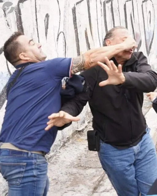 a group of men standing in front of a graffiti covered wall