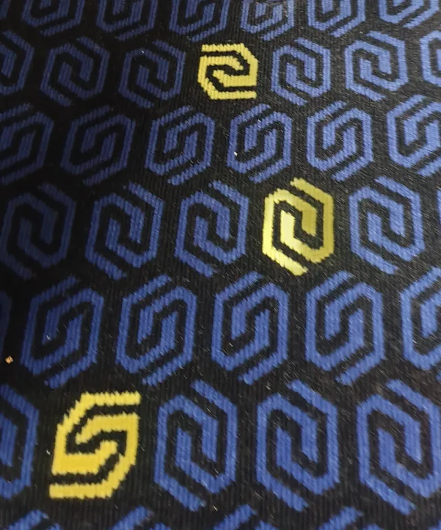 a close up of a tie with yellow and blue designs