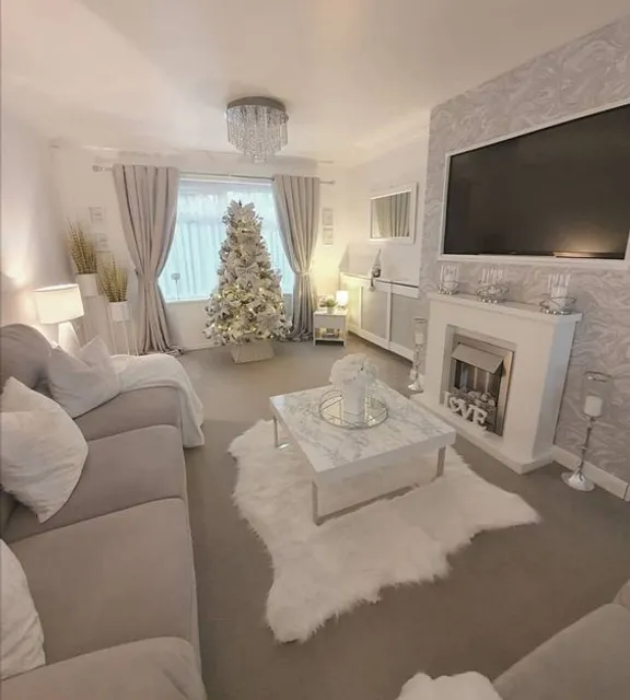 a warm living room with cozy furniture and a festive tree : 3. Clean up the furniture and tree, and add a bit of warmth with some fireplaces and candles.