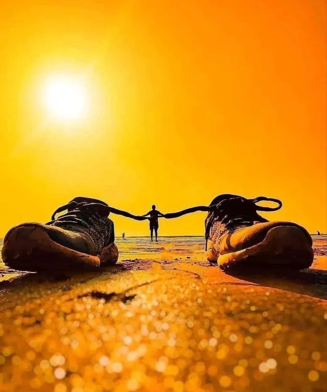 a pair of shoes sitting on top of a sandy beach