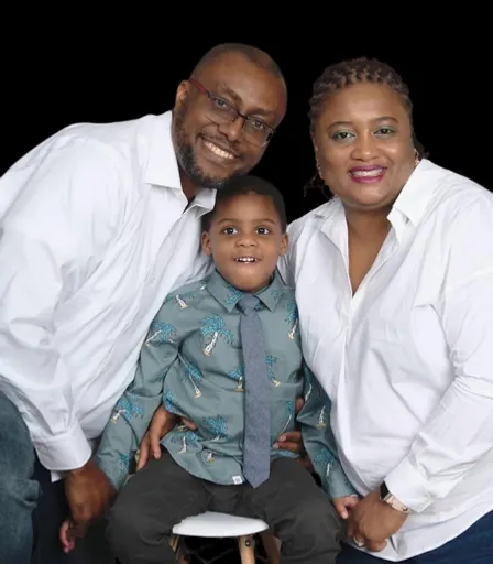 a man and woman pose for a picture with a child