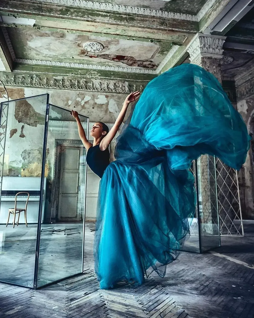 a woman in a blue dress standing in front of a mirror