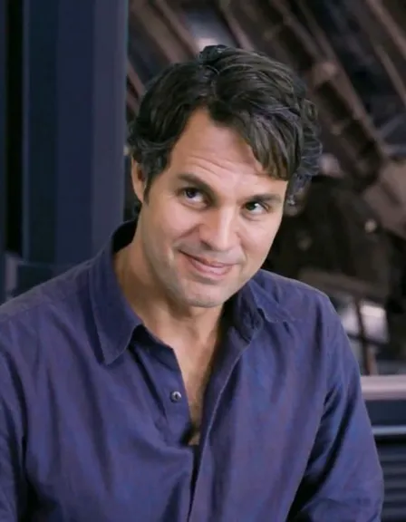 a man in a blue shirt is smiling. forehead, chin, smile, dress shirt, jaw, sleeve, collar, flash photography, white-collar worker, electric blue