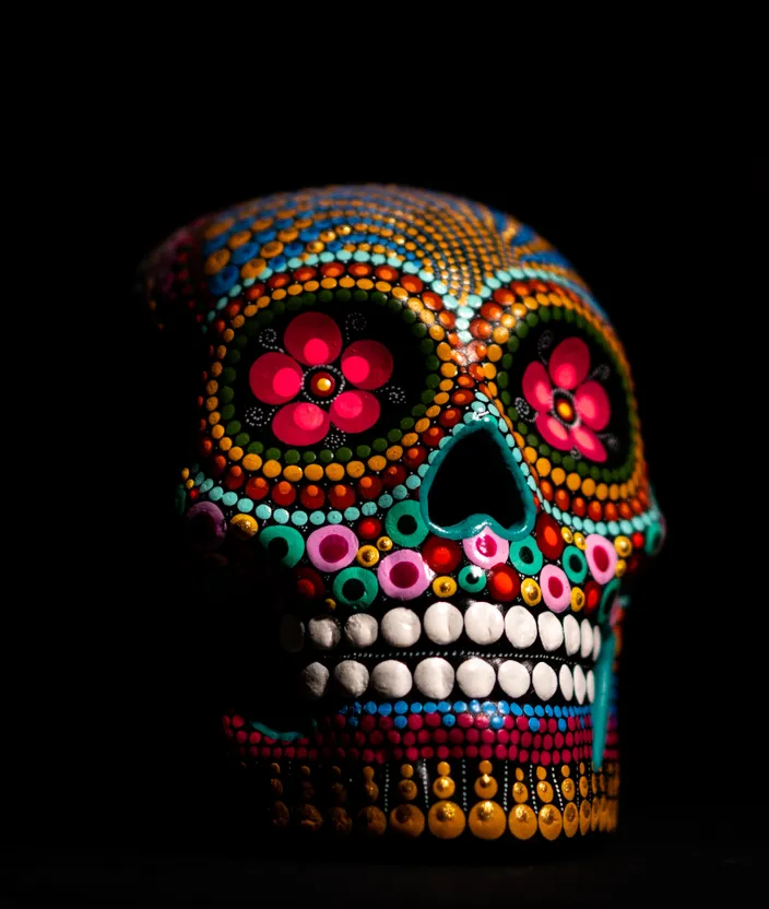 a brightly colored skull is shown in the dark. bone, skull, sunglasses, art, creative arts, jewellery, fashion accessory, font, event, pattern