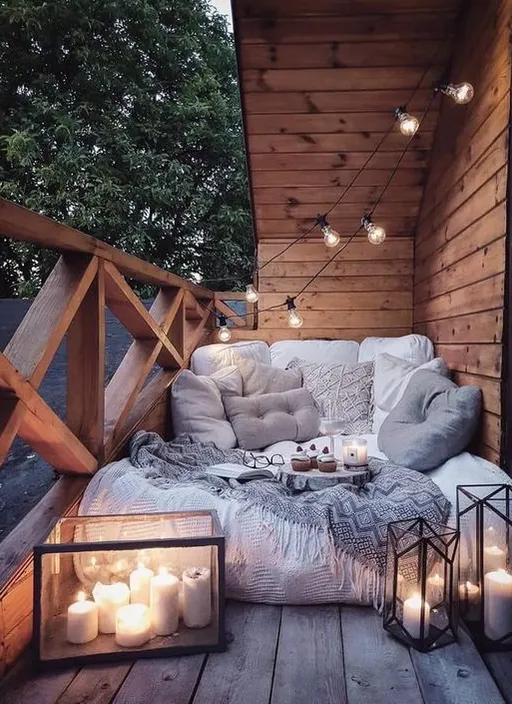 a porch with a couch and some candles on it