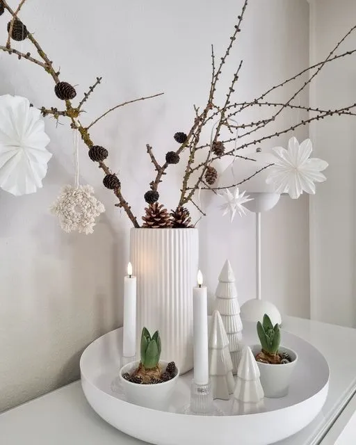 a white table topped with a white vase filled with flowers