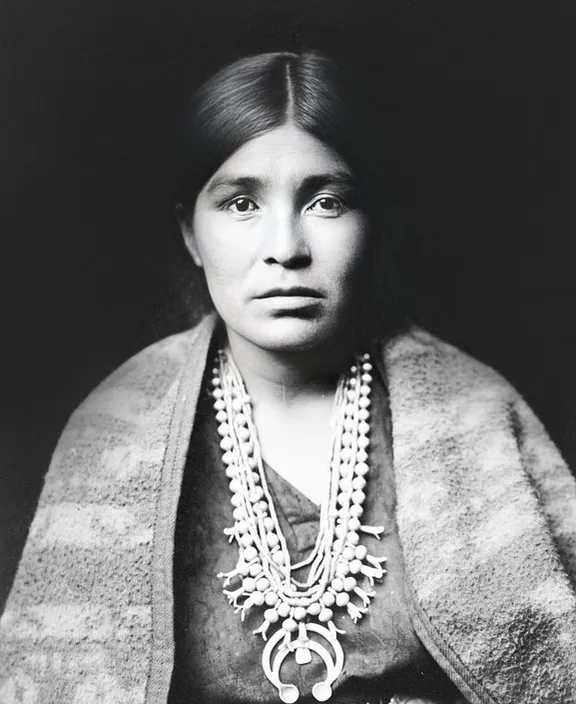 a black and white photo of a woman wearing a necklace