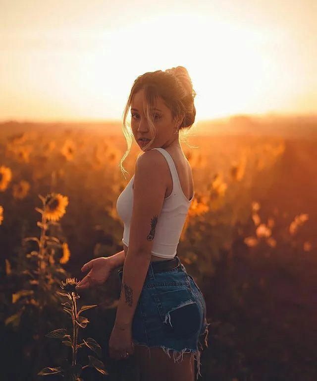 a woman standing in a field of sunflowers