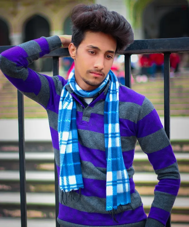 a young man wearing a blue and grey scarf