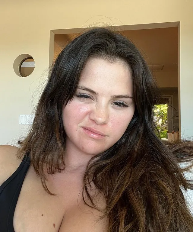 a woman in a black bikini top sitting on a couch