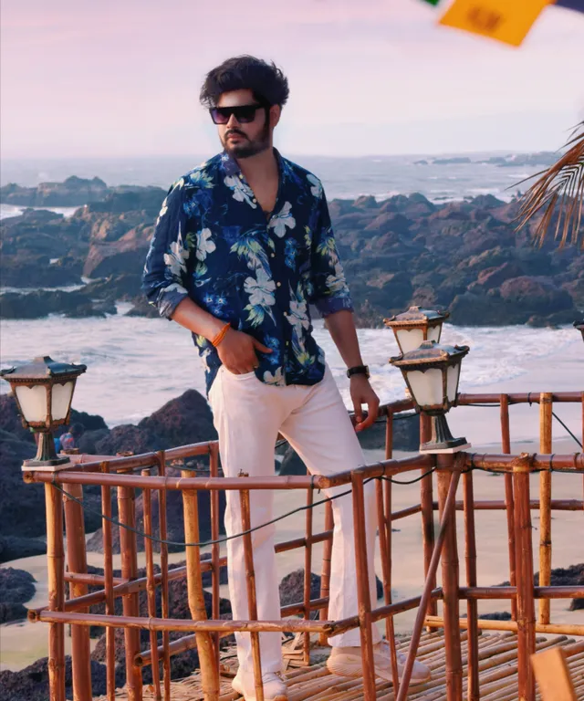 a man standing on a wooden bridge next to the ocean